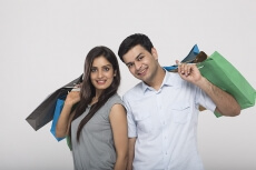 Couple posing with shopping bags while looking at camera