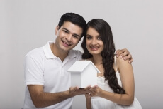 couple posing with toy home