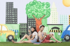 couple sitting back to back in garden eating candy
