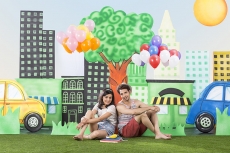 couple sitting back to back in garden holding balloons