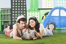 couple reading a book while lying in front view