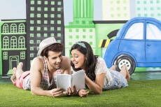 couple reading a book while lying in front view