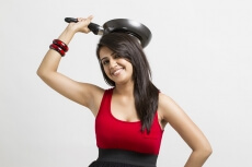 young woman holding fry pan in hands