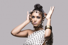 Beautiful woman posing in style holding beads in hands