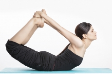 young woman yoga exercise practicing dhanurasana