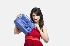 female carrying a blue handbag while posing