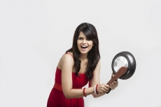 Girl banging wodden spoon and pan